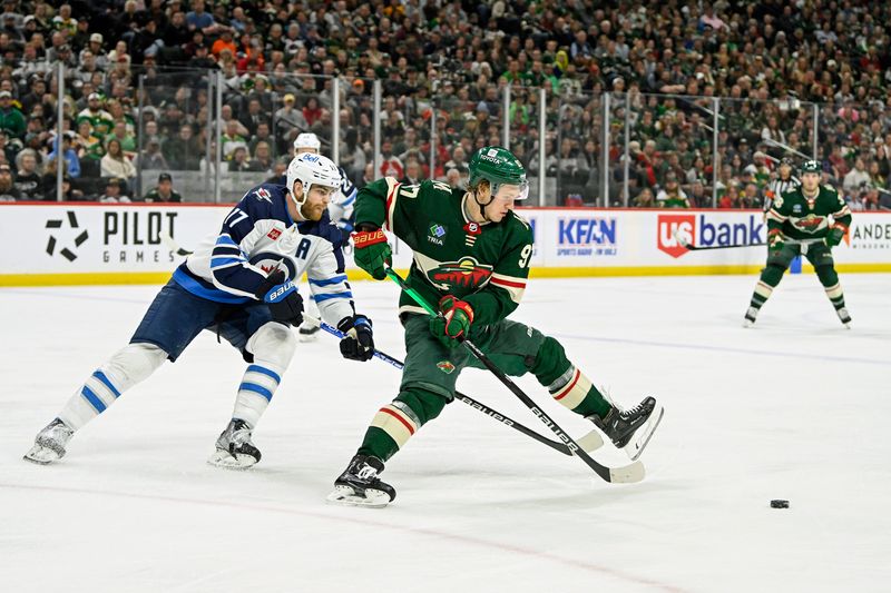 Apr 11, 2023; Saint Paul, Minnesota, USA;  Minnesota Wild forward Kirill Kaprizov (97) protects the puck from Winnipeg Jets defense Kyle Capobianco (77) during the second period at at Xcel Energy Center. Mandatory Credit: Nick Wosika-USA TODAY Sports