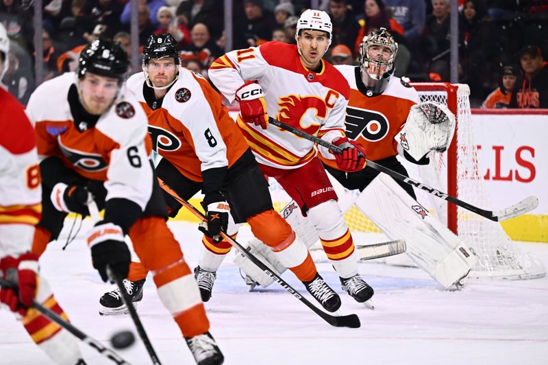 Jan 6, 2024; Philadelphia, Pennsylvania, USA; Calgary Flames center Mikael Backlund (11) watches the puck in front of Philadelphia Flyers goalie Carter Hart (79) in the first period at Wells Fargo Center. Mandatory Credit: Kyle Ross-USA TODAY Sports