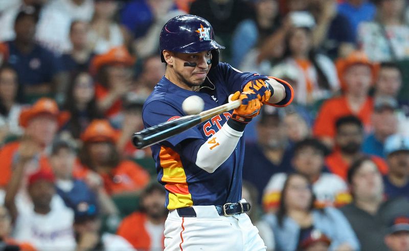 Apr 14, 2024; Houston, Texas, USA; Houston Astros third baseman Mauricio Dubon (14) hits an RBI double during the fourth inning against the Texas Rangers at Minute Maid Park. Mandatory Credit: Troy Taormina-USA TODAY Sports