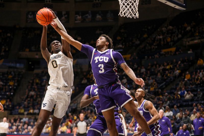 Feb 25, 2025; Morgantown, West Virginia, USA; West Virginia Mountaineers center Eduardo Andre (0) and TCU Horned Frogs guard Vasean Allette (3) jump for a rebound during the first half at WVU Coliseum. Mandatory Credit: Ben Queen-Imagn Images