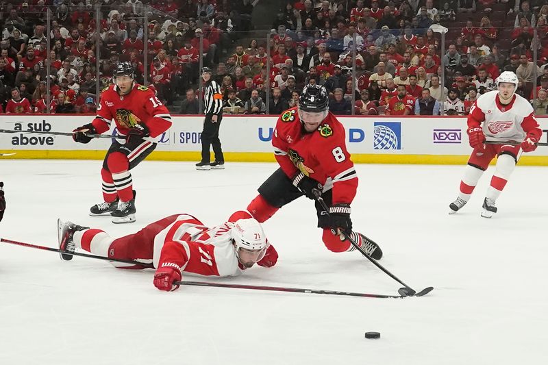 Nov 6, 2024; Chicago, Illinois, USA; Detroit Red Wings center Dylan Larkin (71) and Chicago Blackhawks center Ryan Donato (8) go for the puck during the third period at United Center. Mandatory Credit: David Banks-Imagn Images