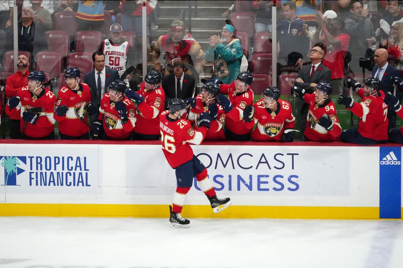 Nov 10, 2023; Sunrise, Florida, USA; Florida Panthers defenseman Uvis Balinskis (26) celebrates with teammates after scoring a goal against the Carolina Hurricanes during the first period at Amerant Bank Arena. Mandatory Credit: Jasen Vinlove-USA TODAY Sports