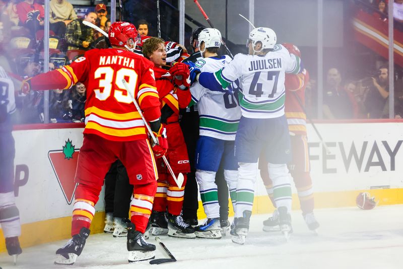 Sep 28, 2024; Calgary, Alberta, CAN; Calgary Flames center Connor Zary (47) gets into a scrum with Vancouver Canucks players during the third period at Scotiabank Saddledome. Mandatory Credit: Sergei Belski-Imagn Images