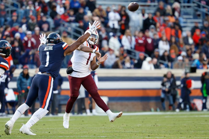 Nov 25, 2023; Charlottesville, Virginia, USA; Virginia Tech Hokies quarterback Kyron Drones (1) passes the ball as Virginia Cavaliers defensive end Paul Akere (1) defends during the first quarter at Scott Stadium. Mandatory Credit: Geoff Burke-USA TODAY Sports