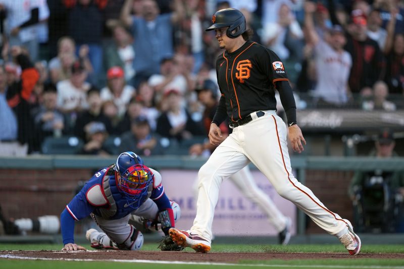 Aug 12, 2023; San Francisco, California, USA; San Francisco Giants first baseman Wilmer Flores (right) scores a run as a throw gets past Texas Rangers catcher Mitch Garver (left) during the first inning at Oracle Park. Mandatory Credit: Darren Yamashita-USA TODAY Sports