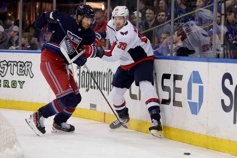 Jan 14, 2024; New York, New York, USA; New York Rangers defenseman K'Andre Miller (79) fights for the puck against Washington Capitals right wing Anthony Mantha (39) during the first period at Madison Square Garden. Mandatory Credit: Brad Penner-USA TODAY Sports