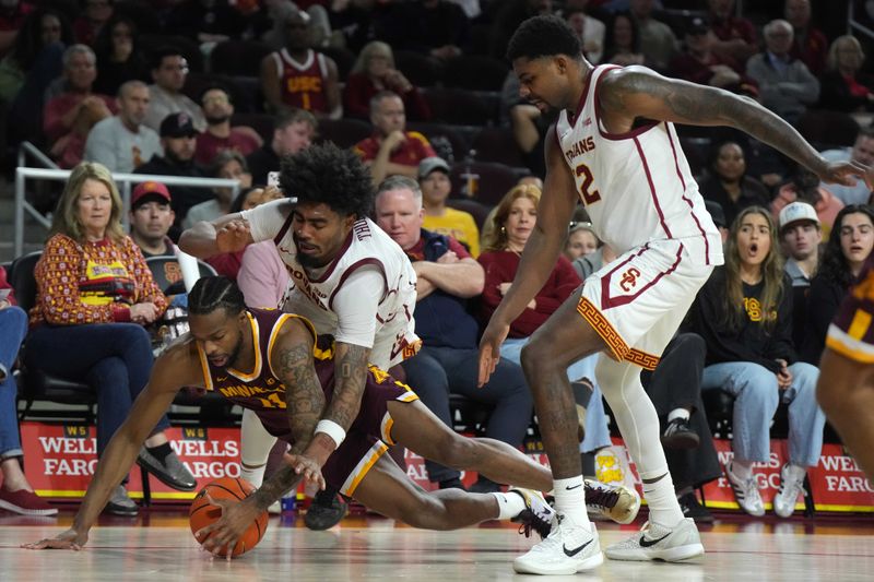 Feb 15, 2025; Los Angeles, California, USA; Minnesota Golden Gophers guard Femi Odukale (11) and Southern California Trojans forward Saint Thomas (0) reach for the ball in the second half at the Galen Center. Mandatory Credit: Kirby Lee-Imagn Images