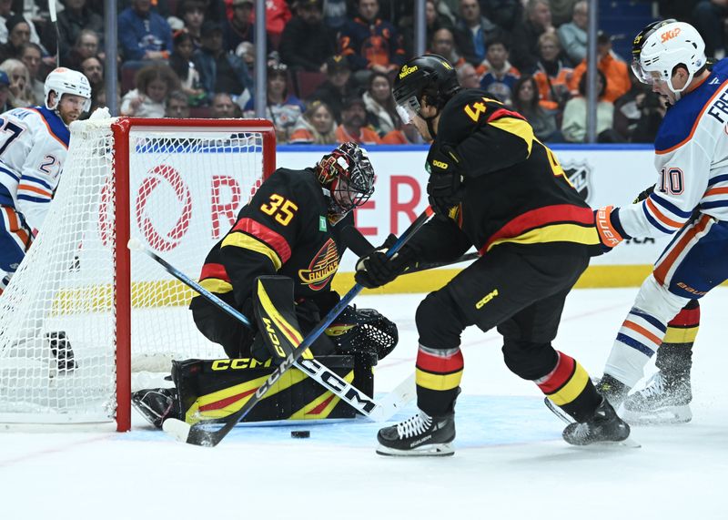 Oct 26, 2025; Vancouver, British Columbia, CAN; Vancouver Canucks left wing Kiefer Sherwood (44) clears the puck from goaltender Thatcher Demko (35) against the Edmonton Oilers during the third period at Rogers Arena. Mandatory Credit: Simon Fearn-Imagn Images