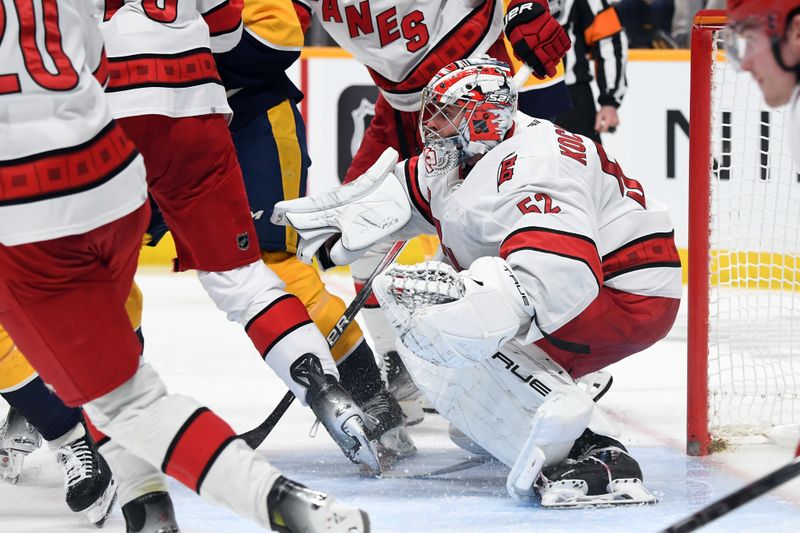 Dec 27, 2023; Nashville, Tennessee, USA; Carolina Hurricanes goaltender Pyotr Kochetkov (52) watches the puck in traffic during the third period against the Nashville Predators at Bridgestone Arena. Mandatory Credit: Christopher Hanewinckel-USA TODAY Sports