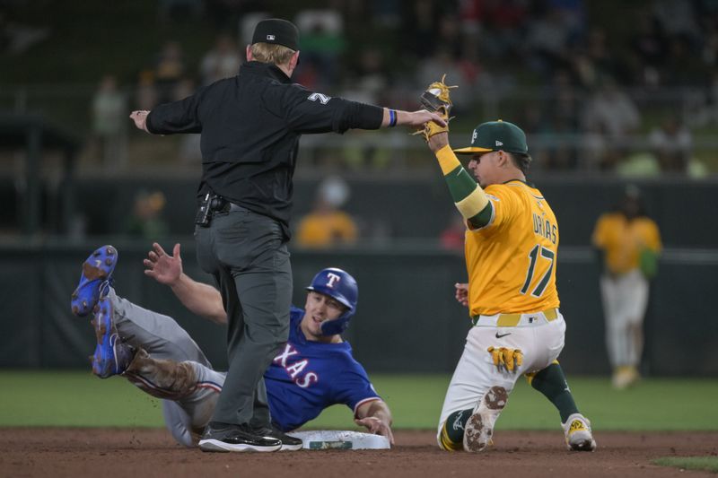 Apr 22, 2025; West Sacramento, California, USA; Athletics third base Luis Urías (17) attempts to tag out Texas Rangers outfielder Wyatt Langford (36) at second base during the eighth inning at Sutter Health Park. Mandatory Credit: Ed Szczepanski-Imagn Images