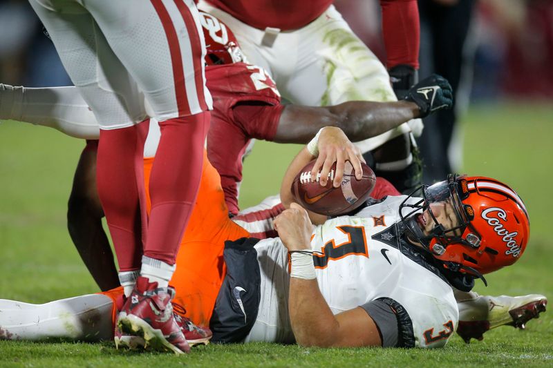 Nov 19, 2022; Norman, Oklahoma, USA; Oklahoma State Cowboys quarterback Spencer Sanders (3) is brought down against the Oklahoma Sooners in the fourth quarter at Gaylord Family-Oklahoma Memorial Stadium. Mandatory Credit: Bryan Terry-USA TODAY Sports