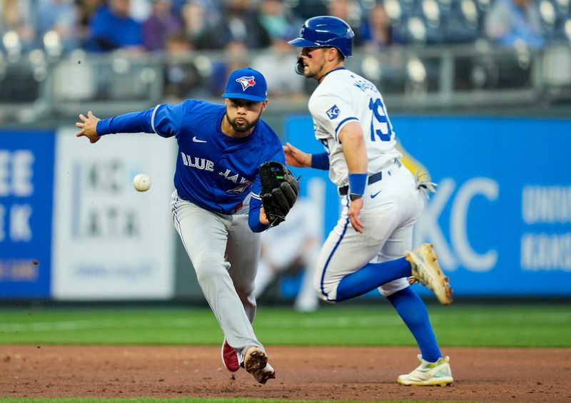 Apr 23, 2024; Kansas City, Missouri, USA; Toronto Blue Jays third base Isiah Kiner-Falefa (7) fields a ground ball as Kansas City Royals second base Michael Massey (19) runs to third base during the third inning at Kauffman Stadium. Mandatory Credit: Jay Biggerstaff-USA TODAY Sports