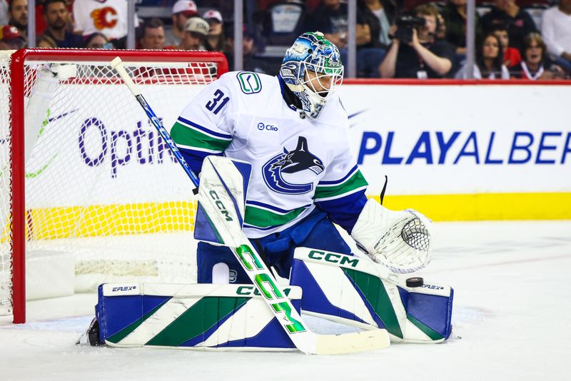 Sep 28, 2024; Calgary, Alberta, CAN; Vancouver Canucks goaltender Arturs Silovs (31) makes a save against the Calgary Flames during the second period at Scotiabank Saddledome. Mandatory Credit: Sergei Belski-Imagn Images