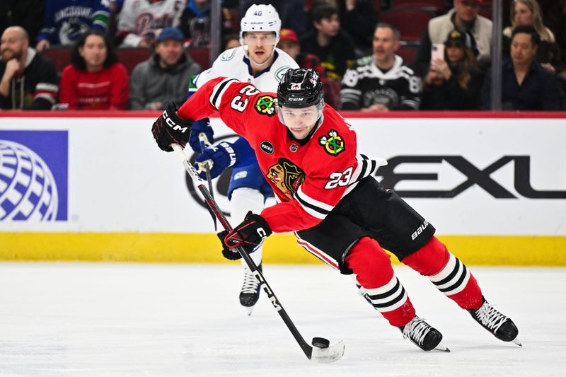 Feb 13, 2024; Chicago, Illinois, USA; Chicago Blackhawks forward Philipp Kurashev (23) controls the puck in the first period against the Vancouver Canucks at United Center. Mandatory Credit: Jamie Sabau-USA TODAY Sports