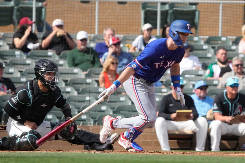 Feb 27, 2024; Salt River Pima-Maricopa, Arizona, USA; Texas Rangers right fielder Evan Carter (32) hits a single against the Arizona Diamondbacks during the second inning at Salt River Fields at Talking Stick. Mandatory Credit: Rick Scuteri-USA TODAY Sports