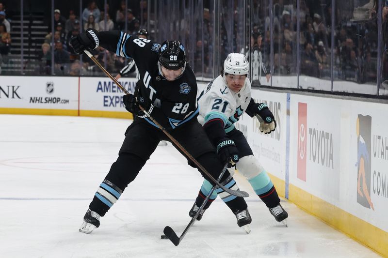 Apr 8, 2025; Salt Lake City, Utah, USA; Utah Hockey Club defenseman Ian Cole (28) and Seattle Kraken center Michael Eyssimont (21) battle for the puck during the first period at Delta Center. Mandatory Credit: Rob Gray-Imagn Images
