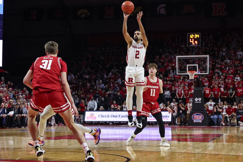 Feb 10, 2024; Piscataway, New Jersey, USA; Rutgers Scarlet Knights guard Noah Fernandes (2) shoots the ball against Wisconsin Badgers guard Max Klesmit (11) and forward Nolan Winter (31) during the second half at Jersey Mike's Arena. Mandatory Credit: Vincent Carchietta-USA TODAY Sports