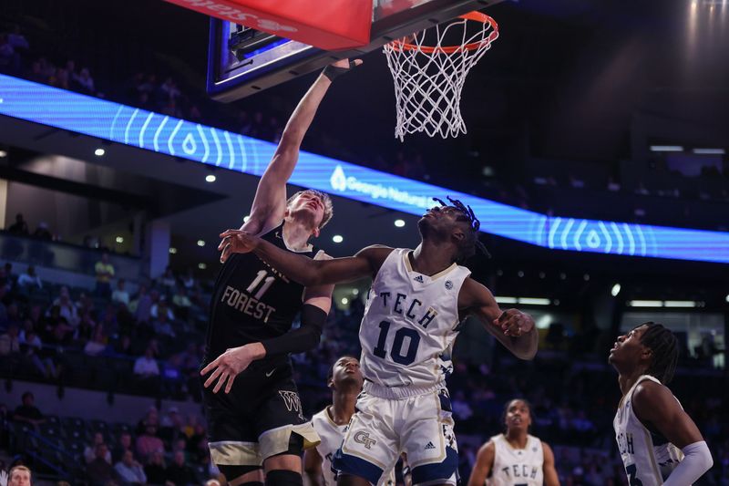 Feb 6, 2024; Atlanta, Georgia, USA; Wake Forest Demon Deacons forward Andrew Carr (11) shoots past Georgia Tech Yellow Jackets forward Ebenezer Dowuona (10) in the first half at McCamish Pavilion. Mandatory Credit: Brett Davis-USA TODAY Sports