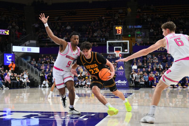 Feb 4, 2026; Seattle, Washington, USA; Iowa Hawkeyes guard Isaia Howard (23) dribbles the ball while guarded by Washington Huskies guard Wesley Yates III (9) during the second half at Alaska Airlines Arena at Hec Edmundson Pavilion. Mandatory Credit: Steven Bisig-Imagn Images