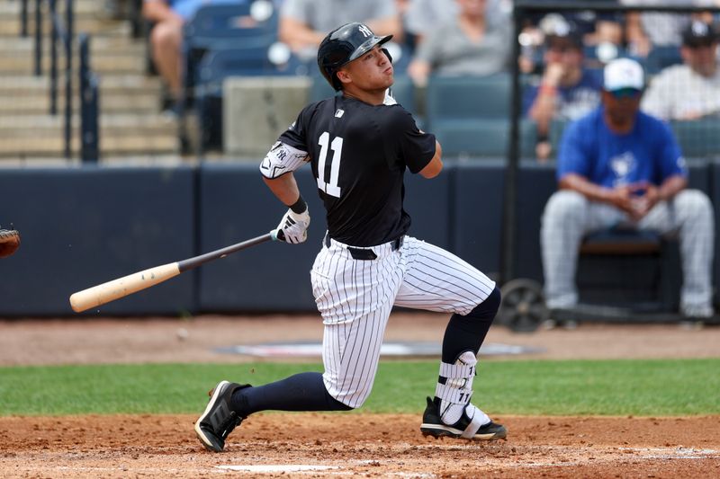 Mar 16, 2024; Tampa, Florida, USA;  New York Yankees shortstop Anthony Volpe (11) hits a base hit against the Toronto Blue Jays in the third inning at George M. Steinbrenner Field. Mandatory Credit: Nathan Ray Seebeck-USA TODAY Sports