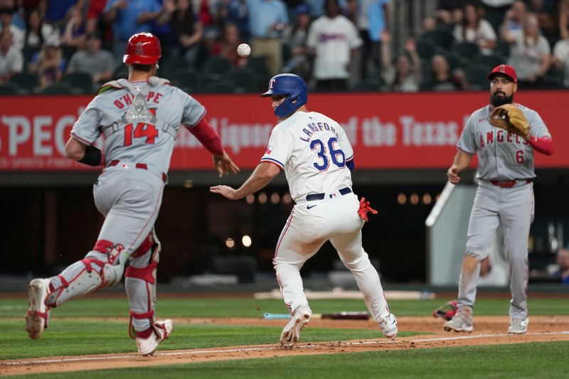 Sep 7, 2024; Arlington, Texas, USA; Texas Rangers center fielder Wyatt Langford (36) is caught in a rundown by Los Angeles Angels third baseman Anthony Rendon (6) and catcher Logan O'Hoppe (14) during the eighth inning at Globe Life Field. Mandatory Credit: Jim Cowsert-Imagn Images