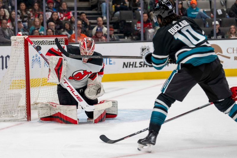 Feb 27, 2024; San Jose, California, USA;  New Jersey Devils goaltender Nico Daws (50) makes a stick save against San Jose Sharks left wing Anthony Duclair (10) during the second period at SAP Center at San Jose. Mandatory Credit: Neville E. Guard-USA TODAY Sports