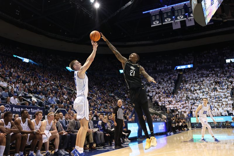 Feb 13, 2024; Provo, Utah, USA; Central Florida Knights forward C.J. Walker (21) blocks the shot of Brigham Young Cougars forward Noah Waterman (0) during the second half at Marriott Center. Mandatory Credit: Rob Gray-USA TODAY Sports