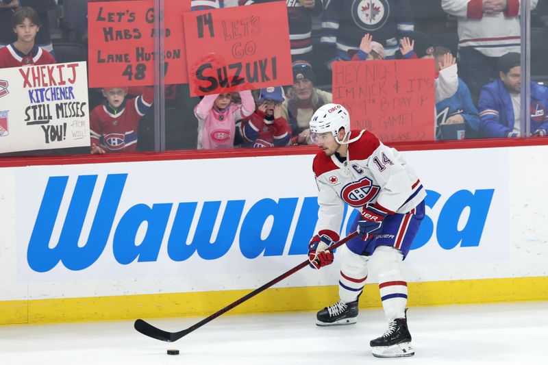 Dec 14, 2024; Winnipeg, Manitoba, CAN; Montreal Canadiens center Nick Suzuki (14) skates past fans before a game against the Winnipeg Jets at Canada Life Centre. Mandatory Credit: James Carey Lauder-Imagn Images