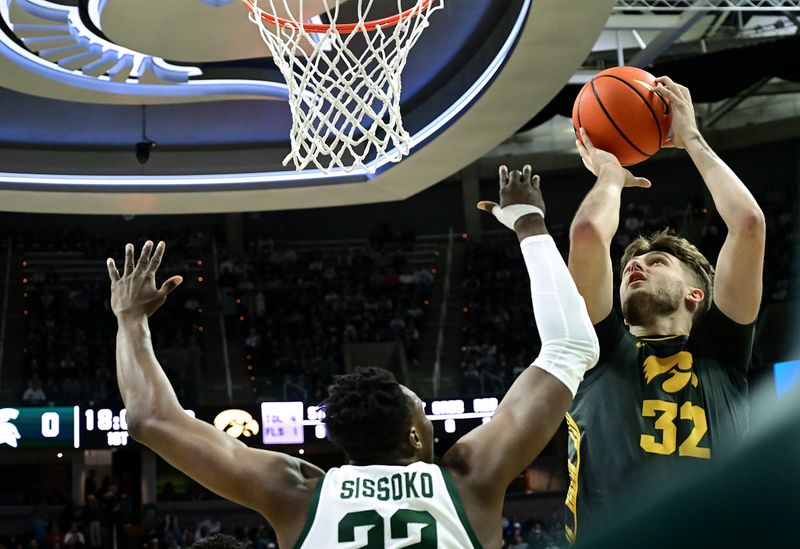 Feb 20, 2024; East Lansing, Michigan, USA;  Iowa Hawkeyes forward Owen Freeman (32) shoots over Michigan State Spartans center Mady Sissoko (22) during the first half at Jack Breslin Student Events Center. Mandatory Credit: Dale Young-USA TODAY Sports
