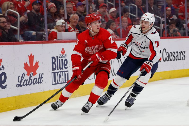 Apr 9, 2024; Detroit, Michigan, USA;  Detroit Red Wings left wing Lucas Raymond (23) skates with the puck chased by Washington Capitals defenseman John Carlson (74) in the second period at Little Caesars Arena. Mandatory Credit: Rick Osentoski-USA TODAY Sports