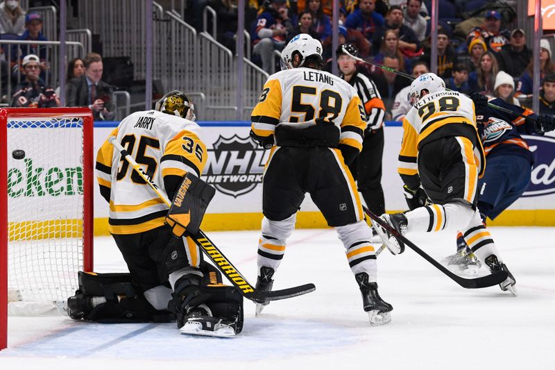 Dec 27, 2022; Elmont, New York, USA; New York Islanders center Mathew Barzal (13) scores a gaol past Pittsburgh Penguins goaltender Tristan Jarry (35) during the second period at UBS Arena. Mandatory Credit: Dennis Schneidler-USA TODAY Sports