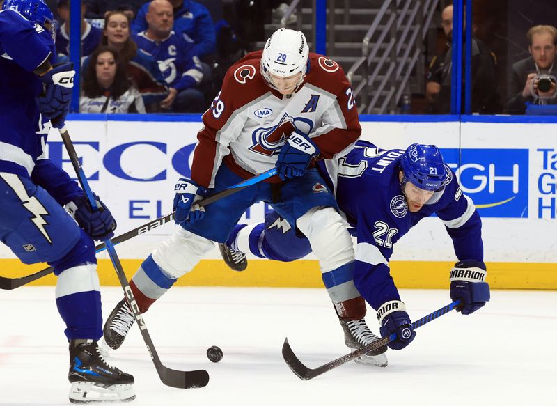 Jan 6, 2026; Tampa, Florida, USA; Colorado Avalanche center Nathan MacKinnon (29) skates with the puck as Tampa Bay Lightning center Brayden Point (21) attempted to defend during the second period at Benchmark International Arena. Mandatory Credit: Kim Klement Neitzel-Imagn Images