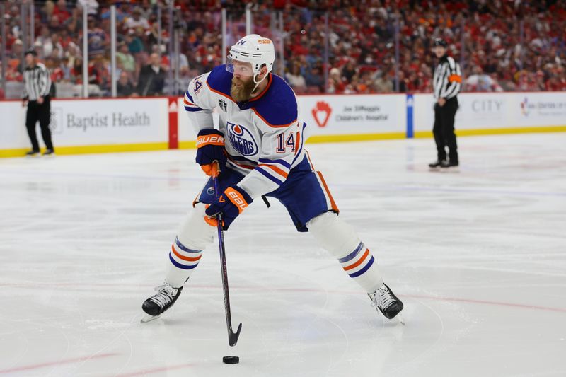 Jun 24, 2024; Sunrise, Florida, USA; Edmonton Oilers defenseman Mattias Ekholm (14) controls the puck  during the third period against the Florida Panthers in game seven of the 2024 Stanley Cup Final at Amerant Bank Arena. Mandatory Credit: Sam Navarro-USA TODAY Sports