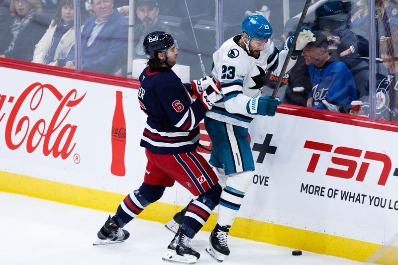 Oct 18, 2024; Winnipeg, Manitoba, CAN;  Winnipeg Jets defenseman Colin Miller (6) bodies San Jose Sharks forward Barclay Goodrow (23) during the third period at Canada Life Centre. Mandatory Credit: Terrence Lee-Imagn Images