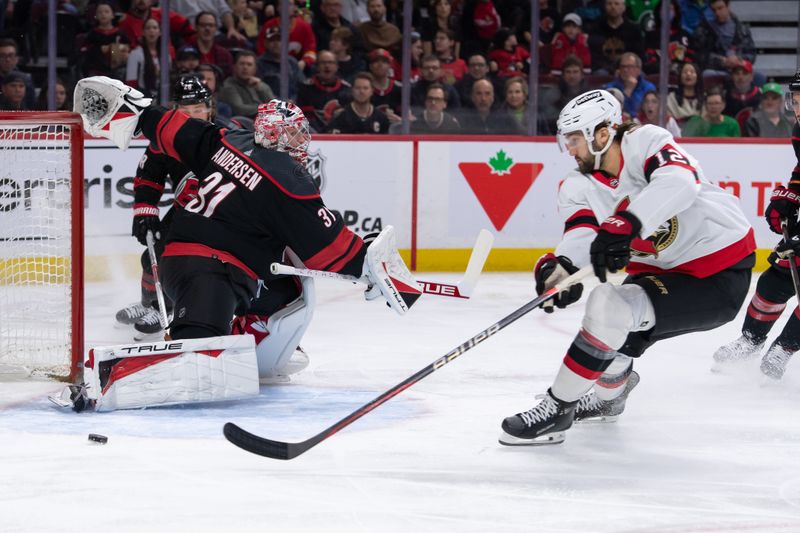 Mar 17, 2024; Ottawa, Ontario, CAN; Ottawa Senators center Mark Kastelic (12) chases the puck as he skates past Carolina Hurricanes goalie Frederik Andersen (31) in the first period at the Canadian Tire Centre. Mandatory Credit: Marc DesRosiers-USA TODAY Sports