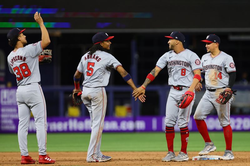 Apr 29, 2024; Miami, Florida, USA; Washington Nationals shortstop CJ Abrams (5) celebrates with right fielder Eddie Rosario (8) and second baseman Ildemaro Vargas (14) after the game against the Miami Marlins at loanDepot Park. Mandatory Credit: Sam Navarro-USA TODAY Sports