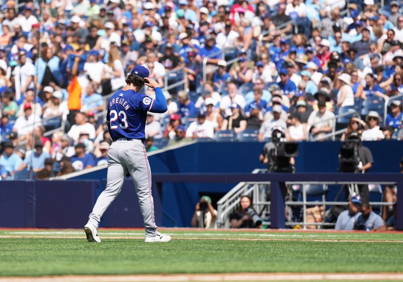 Jul 27, 2024; Toronto, Ontario, CAN; Texas Rangers starting pitcher Michael Lorenzen (23) walks towards the dugout after being relieved against the Toronto Blue Jays during the first inning at Rogers Centre. Mandatory Credit: Nick Turchiaro-USA TODAY Sports