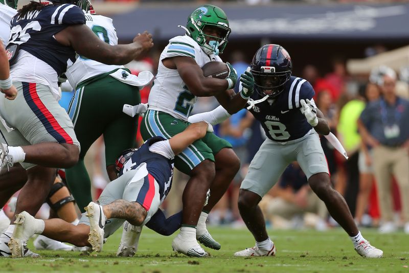 Sep 20, 2025; Oxford, Mississippi, USA; Tulane Green Wave running back Javin Gordon (23) runs the ball as Mississippi Rebels defensive backs Kapena Gushiken (14) and Antonio Kite (8) make the tackle during the second quarter at Vaught-Hemingway Stadium. Mandatory Credit: Petre Thomas-Imagn Images