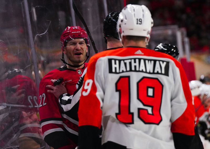 Mar 21, 2024; Raleigh, North Carolina, USA; Carolina Hurricanes defenseman Brett Pesce (22) has words with Philadelphia Flyers right wing Garnet Hathaway (19) during the third period at PNC Arena. Mandatory Credit: James Guillory-USA TODAY Sports