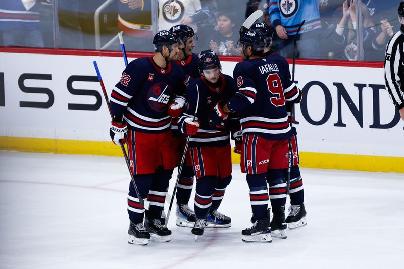 Oct 18, 2024; Winnipeg, Manitoba, CAN;  Winnipeg Jets forward Cole Perfetti (91) is congratulated by his teammates on his goal against the San Jose Sharks during the third period at Canada Life Centre. Mandatory Credit: Terrence Lee-Imagn Images