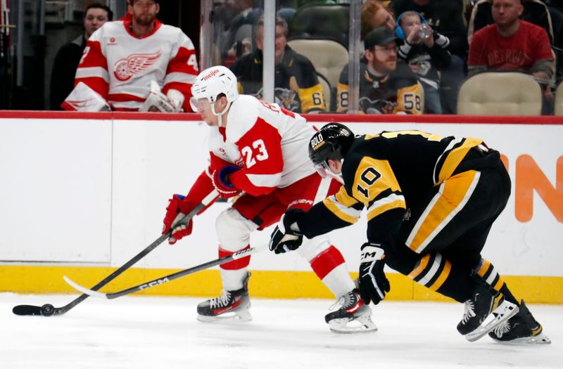 Mar 17, 2024; Pittsburgh, Pennsylvania, USA;  Detroit Red Wings left wing Lucas Raymond (23) skates with the puck against Pittsburgh Penguins left wing Drew O'Connor (10) during the second period at PPG Paints Arena. Mandatory Credit: Charles LeClaire-USA TODAY Sports