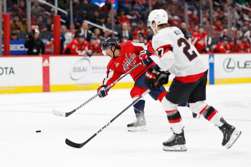 Feb 26, 2024; Washington, District of Columbia, USA; Washington Capitals defenseman Ethan Bear (25) shoots the puck as Ottawa Senators center Shane Pinto (57) chases in the third period at Capital One Arena. Mandatory Credit: Geoff Burke-USA TODAY Sports