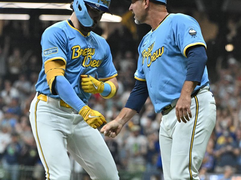 Sep 20, 2024; Milwaukee, Wisconsin, USA; Milwaukee Brewers third base coach Jason Lane (40) congratulates outfielder Garrett Mitchell (5) after hitting a home run against the Arizona Diamondbacks in the fifth inning at American Family Field. Mandatory Credit: Michael McLoone-Imagn Images