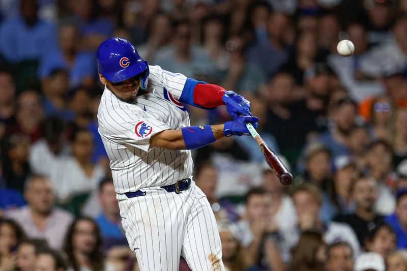 Sep 19, 2024; Chicago, Illinois, USA; Chicago Cubs third baseman Isaac Paredes (17) hits an RBI-sacrifice fly against the Washington Nationals during the fifth inning at Wrigley Field. Mandatory Credit: Kamil Krzaczynski-Imagn Images