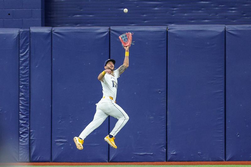 Sep 5, 2024; St. Petersburg, Florida, USA; Tampa Bay Rays outfielder Jose Siri (22) leaps for a ball against the Minnesota Twins in the ninth inning at Tropicana Field. Mandatory Credit: Nathan Ray Seebeck-Imagn Images