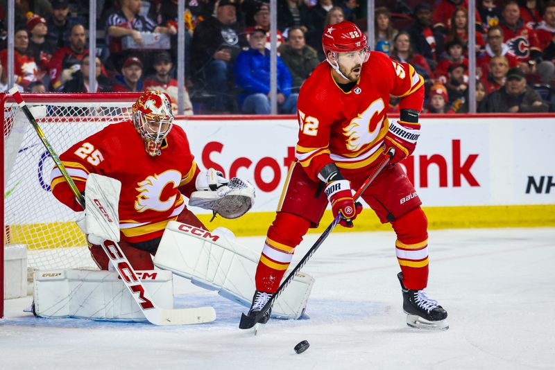 Mar 4, 2024; Calgary, Alberta, CAN; Calgary Flames defenseman MacKenzie Weegar (52) controls the puck in front of Calgary Flames goaltender Jacob Markstrom (25) during the first period against the Seattle Kraken at Scotiabank Saddledome. Mandatory Credit: Sergei Belski-USA TODAY Sports