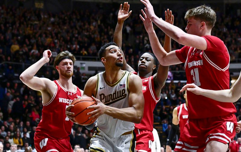 Feb 15, 2025; West Lafayette, Indiana, USA; Purdue Boilermakers forward Trey Kaufman-Renn (4) is surrounded by Wisconsin Badgers under the basket during the second half at Mackey Arena. Mandatory Credit: Marc Lebryk-Imagn Images