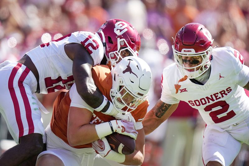 Oct 7, 2023; Dallas, Texas, USA; Texas Longhorns tight end Gunnar Helm (85) fights for yardage against Oklahoma Sooners defensive back Key Lawrence (12) and defensive back Billy Bowman Jr. (2) in the second half at the Cotton Bowl. This game makes up the 119th rivalry match up. Mandatory Credit: Ricardo B. Brazziell-USA TODAY Sports