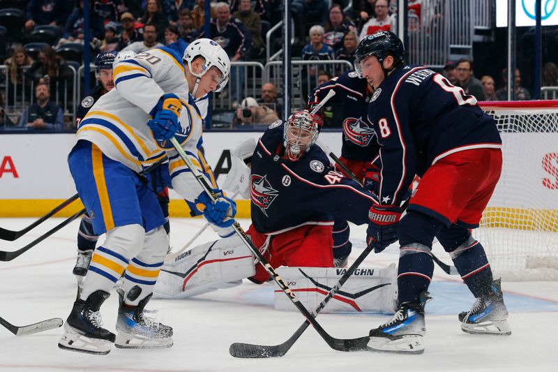 Oct 17, 2024; Columbus, Ohio, USA; Columbus Blue Jackets defenseman Zach Werenski (8) deflects the puck away from Buffalo Sabres center Jiri Kulich (20)  during the third period at Nationwide Arena. Mandatory Credit: Russell LaBounty-Imagn Images