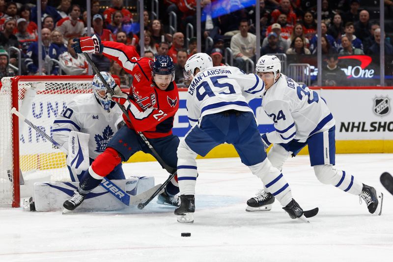 Nov 13, 2024; Washington, District of Columbia, USA; Washington Capitals right wing Brandon Duhaime (22) and Toronto Maple Leafs defenseman Oliver Ekman-Larsson (95) battle for the puck in front of Maple Leafs goaltender Joseph Woll (60) in the first period at Capital One Arena. Mandatory Credit: Geoff Burke-Imagn Images